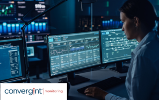 Female Software Engineer Working in a Modern Monitoring Office with Live Analysis Feed with Charts on a Big Digital Screen. Monitoring Room Big Data Scientists and Managers Sit in Front of Computers.