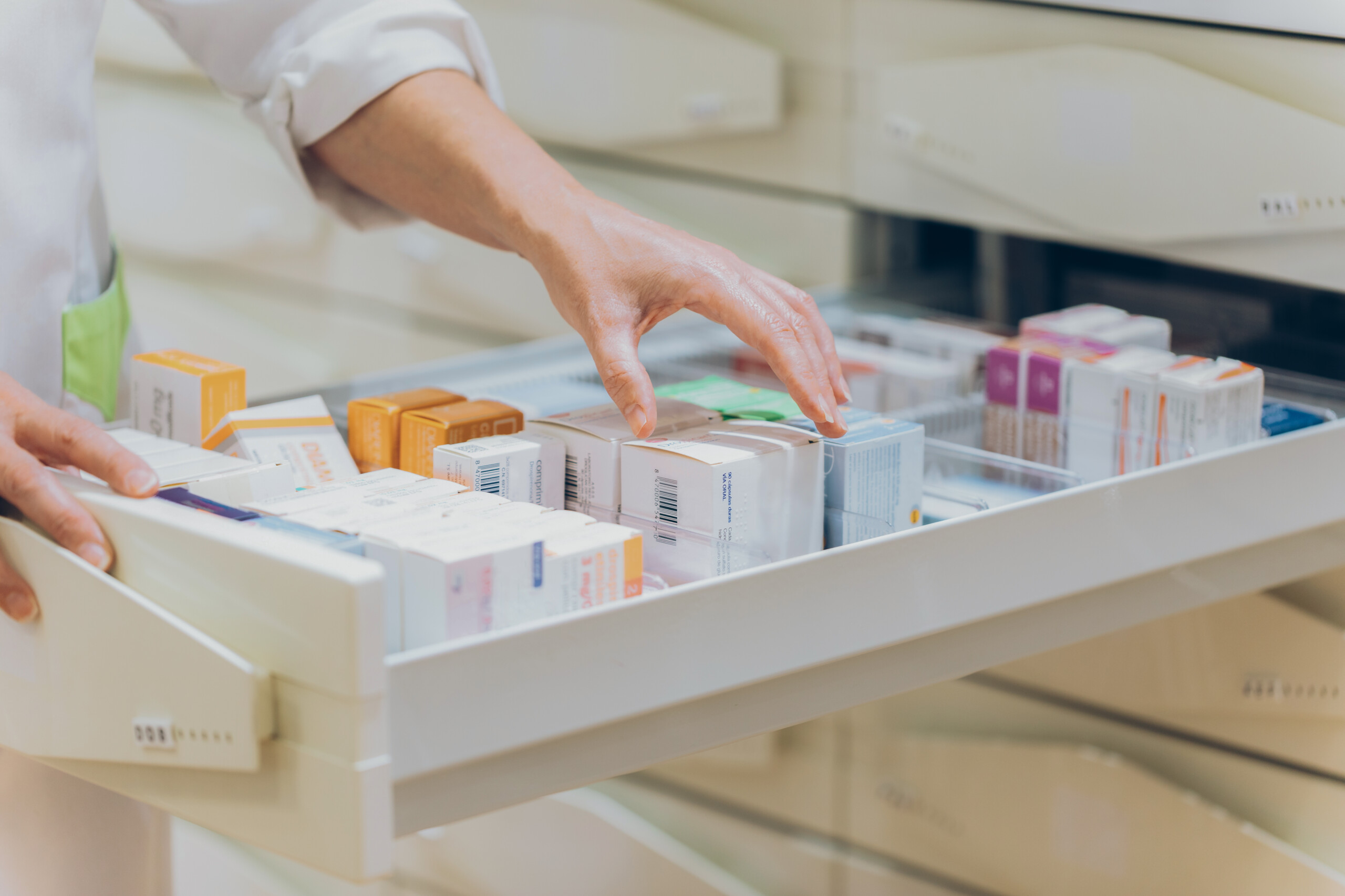 Pharmacist hand taking medication from drawer