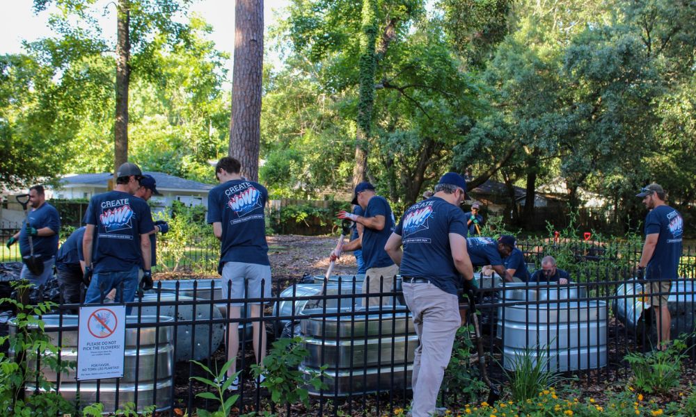 A group of people working on raised planter beds in blue shirts